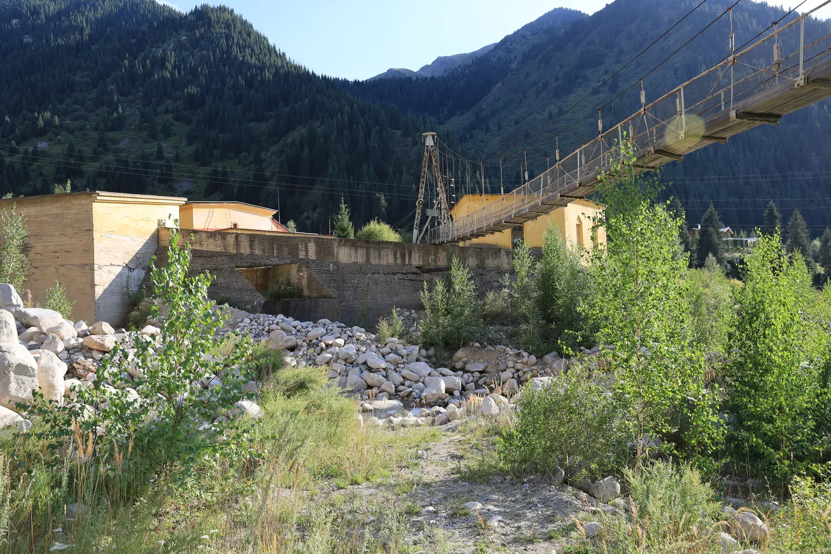 The hydroelectric station, with a pedestrian suspension bridge crossing the Kumbel river.